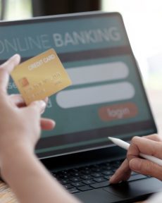 Online payment,woman's hands holding a credit card and using laptop computer for online shopping with vintage filter tone.